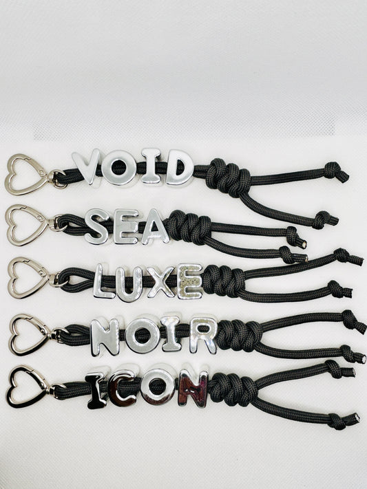 Schlüsselanhänger mit Worten VOID LUXE NOIR ICON. Statement Charm mit silbernem Ring. Tasche & Schlüssel Accessoire