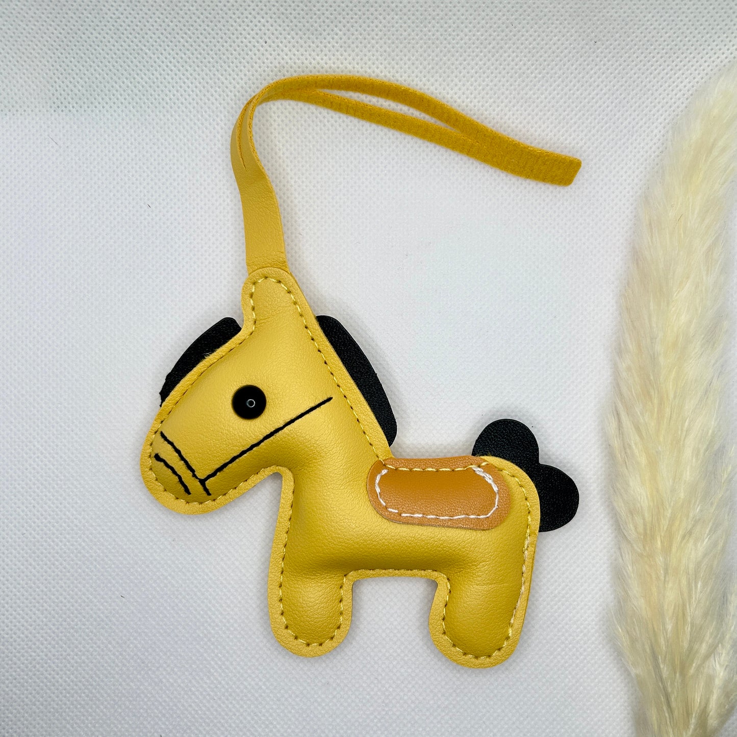 Pony Schlüsselanhänger Kunstleder. Verspielter Taschenanhänger mit Cartoon-Pferd