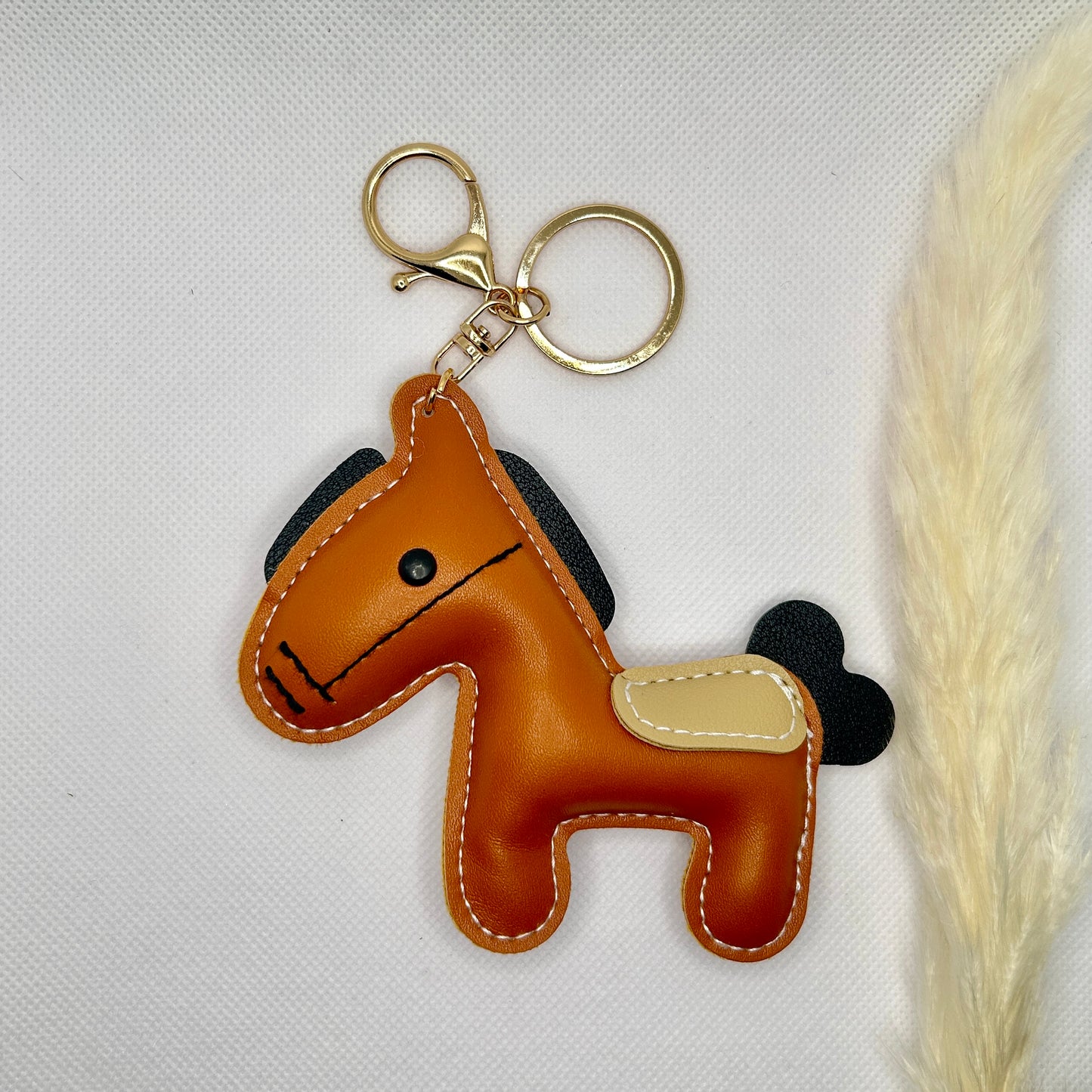 Pony Schlüsselanhänger Kunstleder. Verspielter Taschenanhänger mit Cartoon-Pferd