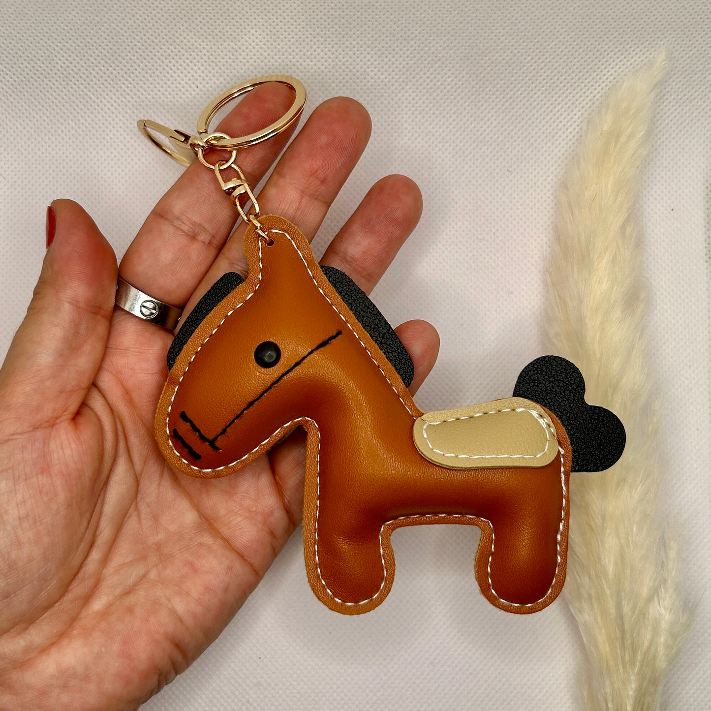 Pony Schlüsselanhänger Kunstleder. Verspielter Taschenanhänger mit Cartoon-Pferd