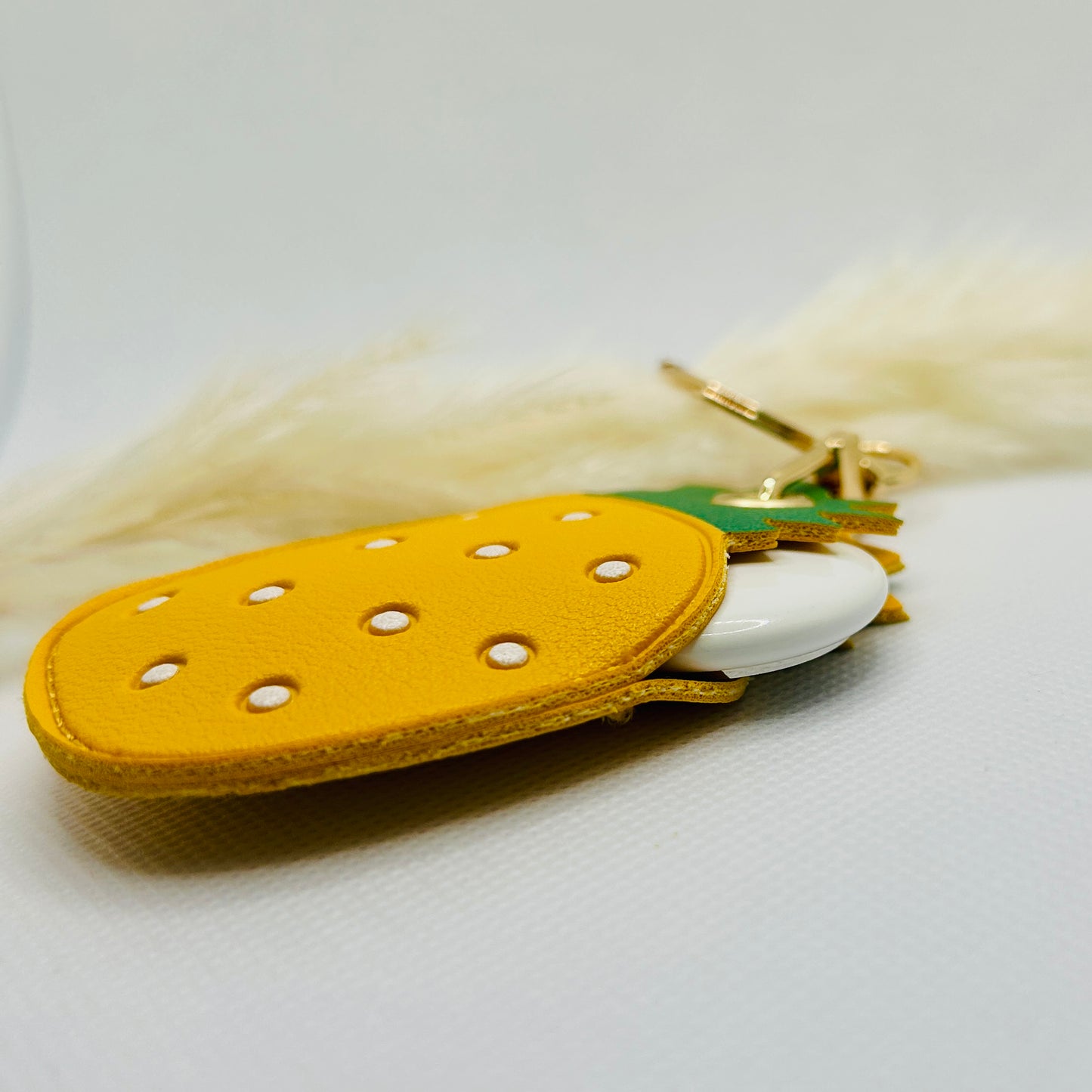 Porte-clés ananas en similicuir. Accessoire estival avec un compartiment pour AirTag ou pièces de monnaie.