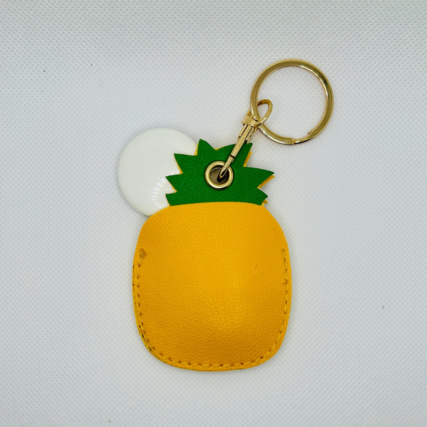 Porte-clés ananas en similicuir. Accessoire estival avec un compartiment pour AirTag ou pièces de monnaie.