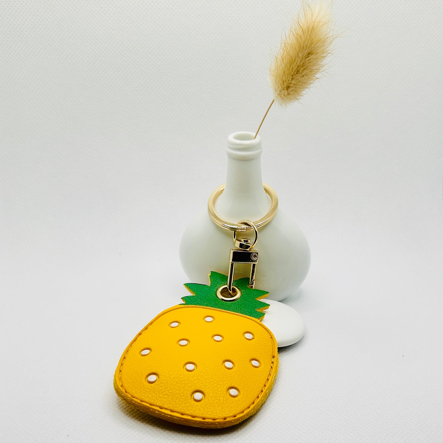 Porte-clés ananas en similicuir. Accessoire estival avec un compartiment pour AirTag ou pièces de monnaie.