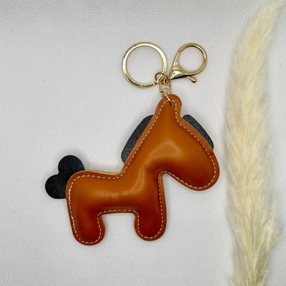 Pony Schlüsselanhänger Kunstleder. Verspielter Taschenanhänger mit Cartoon-Pferd