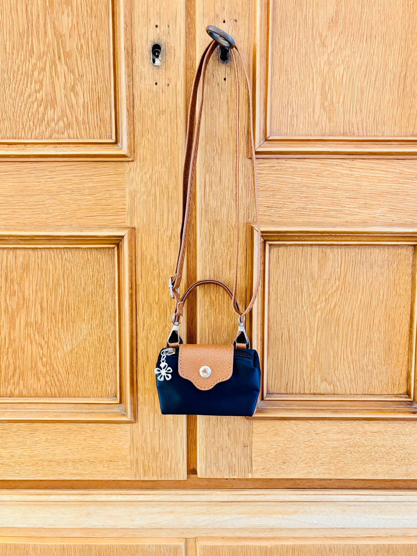 Mini Bag in schwrz braun an Schrank hängend