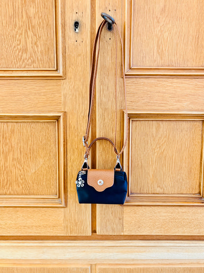 Mini Bag in schwrz braun an Schrank hängend
