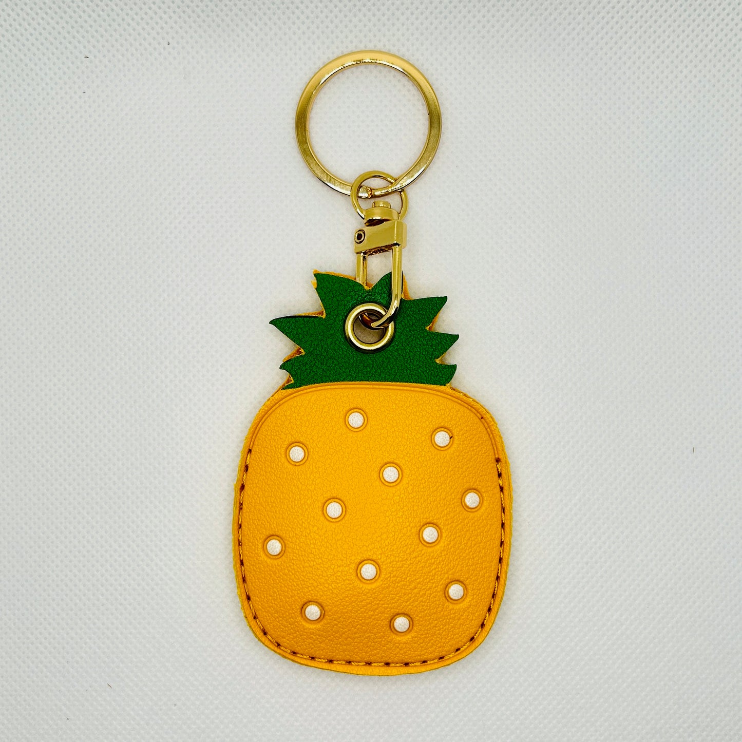 Porte-clés ananas en similicuir. Accessoire estival avec un compartiment pour AirTag ou pièces de monnaie.