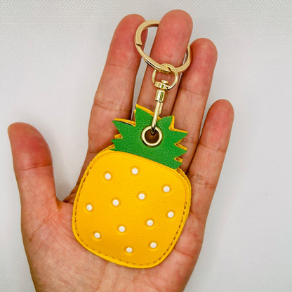 Porte-clés ananas en similicuir. Accessoire estival avec un compartiment pour AirTag ou pièces de monnaie.