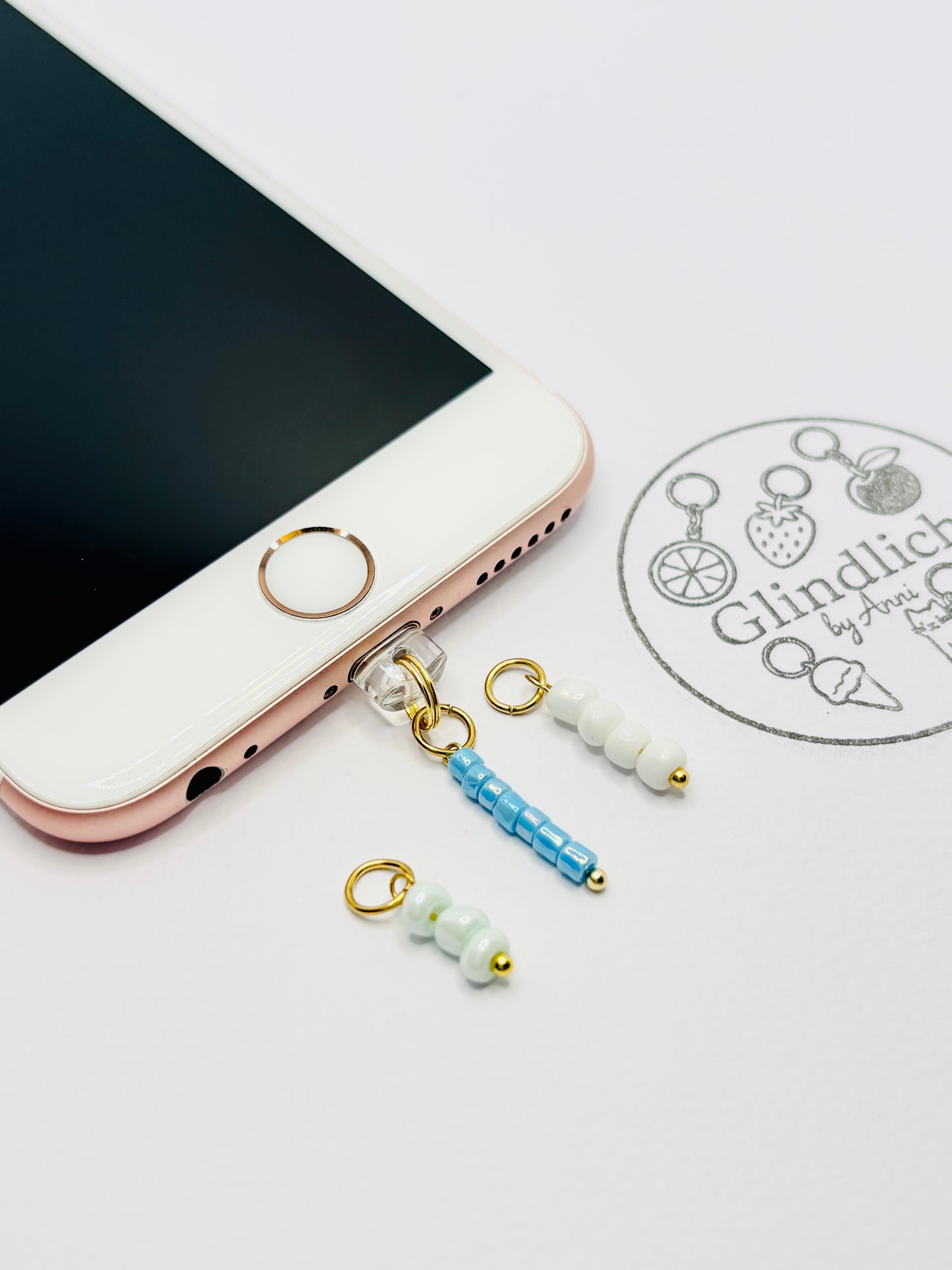 Mini Charm mit blauen, pastellgrünen und weißen Perlen in Gold. Edles Smartphone-Detail