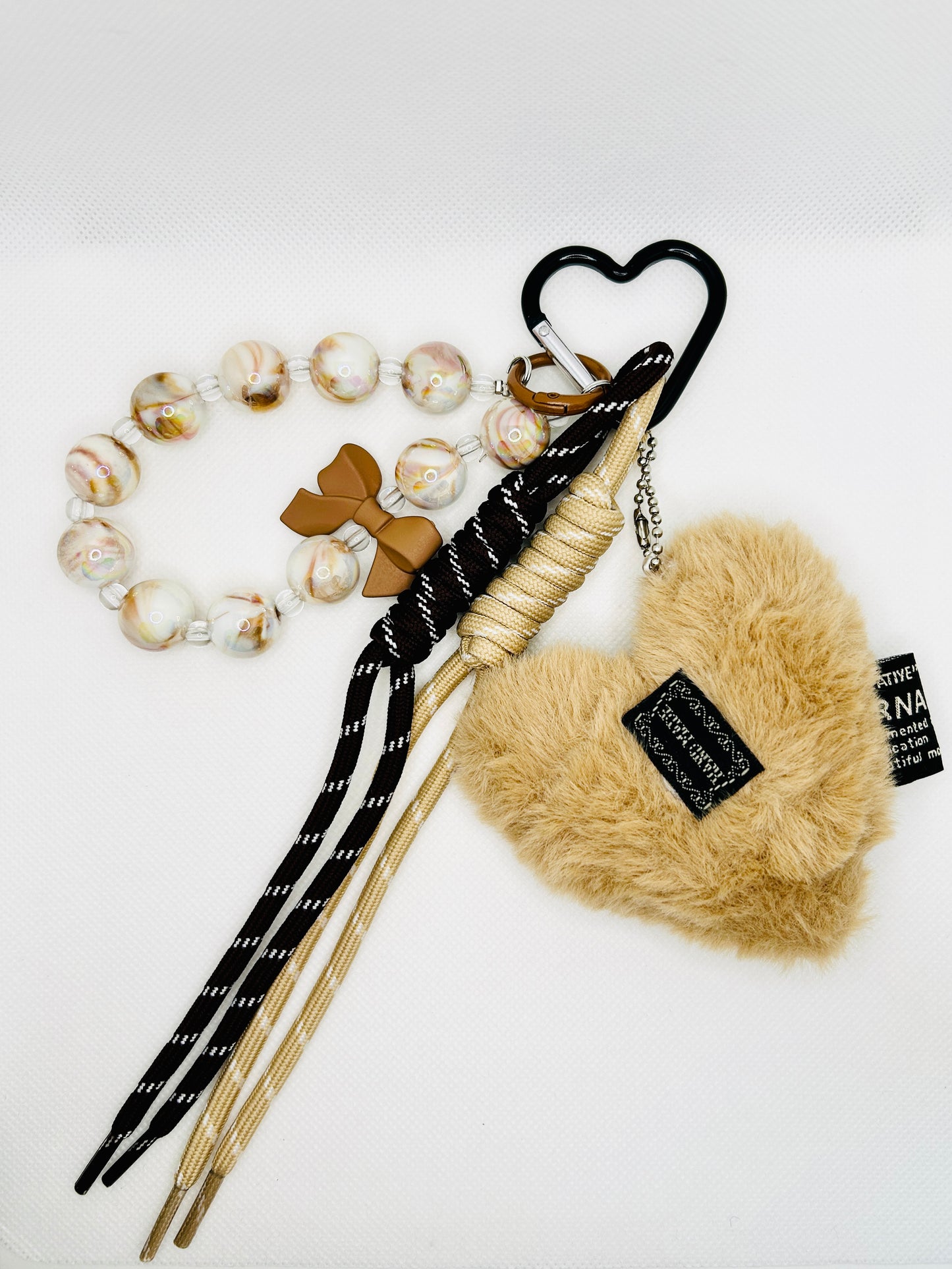 Flauschiger Herz Taschenanhänger in Beige mit Perlen & Schleife. Winterlicher Schlüsselanhänger für Damen