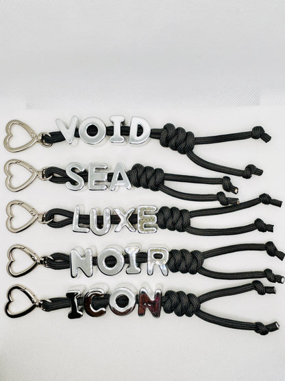 Schlüsselanhänger mit Worten VOID LUXE NOIR ICON. Statement Charm mit silbernem Ring. Tasche & Schlüssel Accessoire