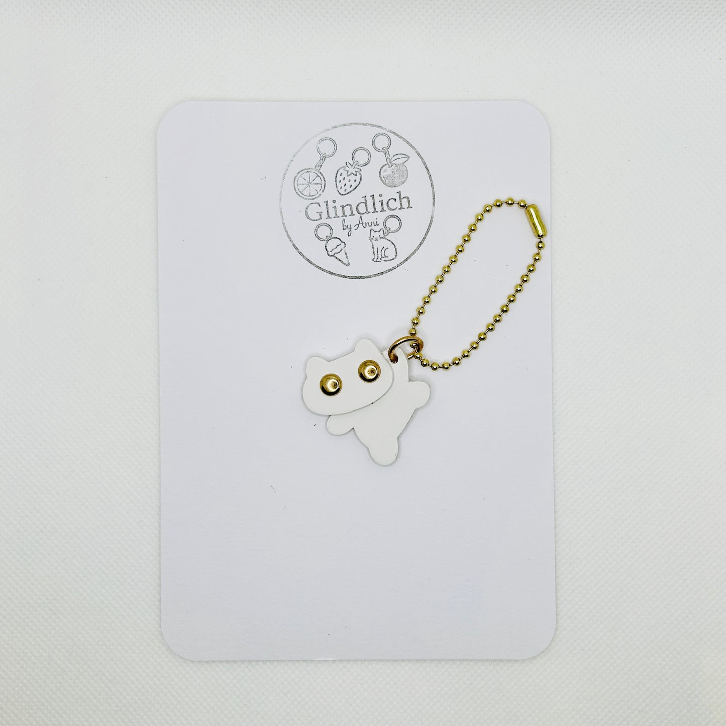 Minimalistischer Katzen Schlüsselanhänger aus Kunstleder. Modernes Design mit goldener Kugelkette.